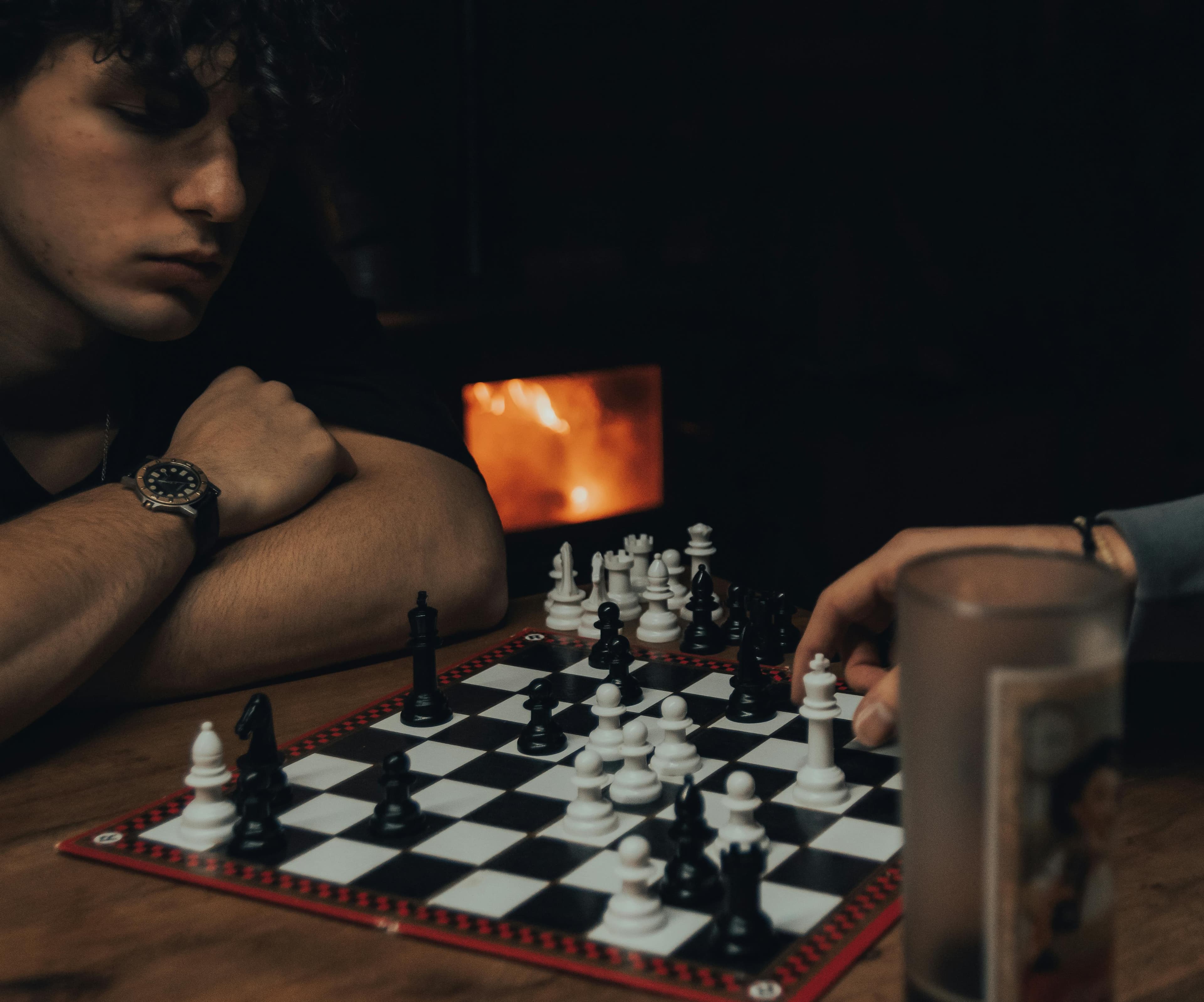 Zwei Leute spielen Schach am Kaminfeuer